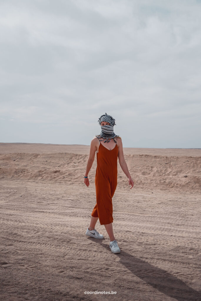 Sarah walking in the Desert with her face covered in a scarf