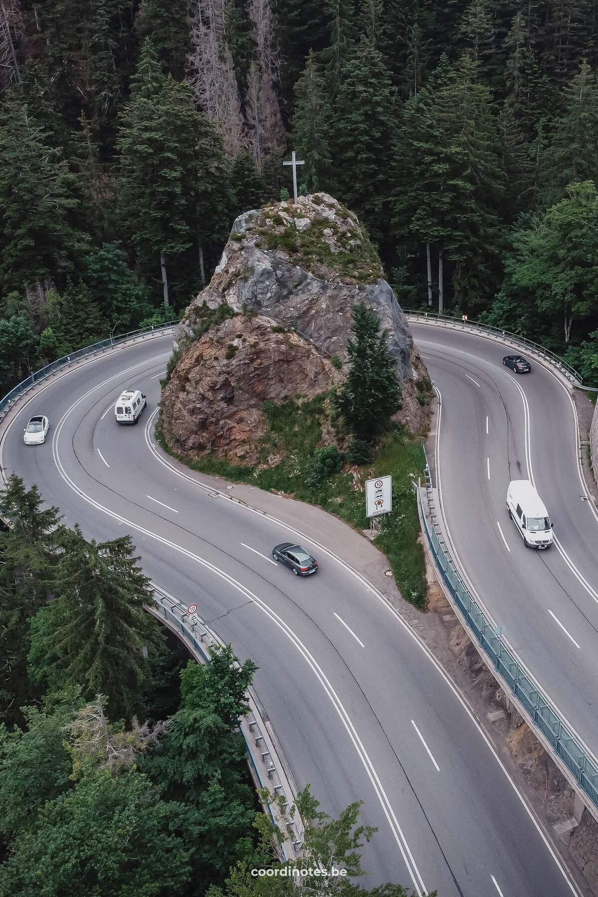 The 360° Kreuzfelsenkurve turn in the road around a huge rock with a cross on top