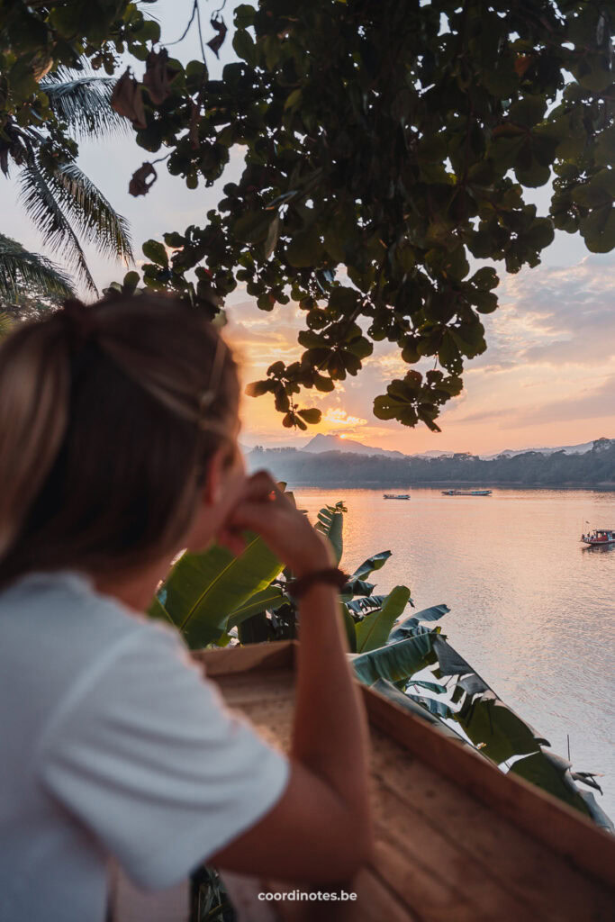 Sarah watching the sun set behind the mountains from a bar at the river side in Luang Prabang