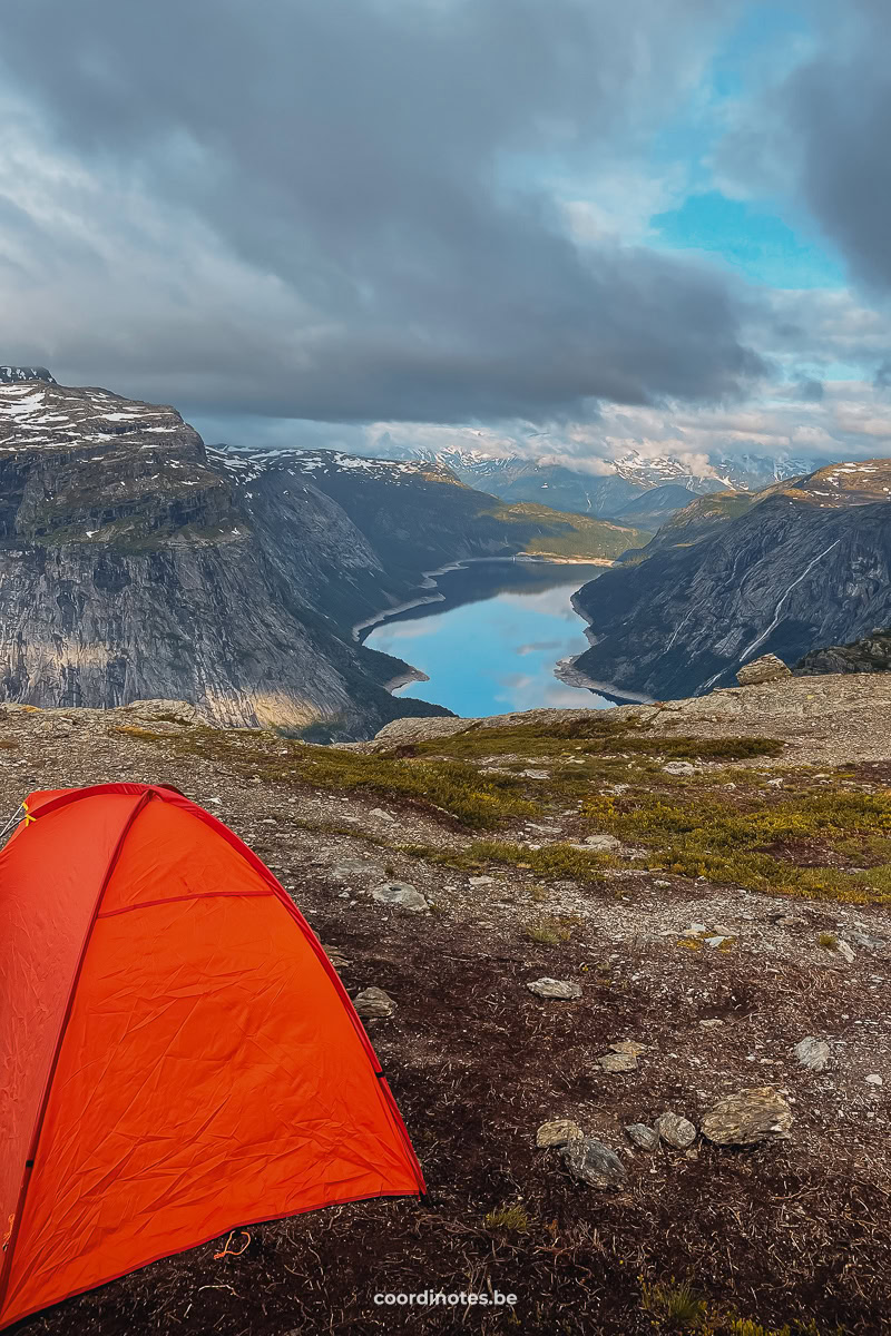 Our tent on a rcoky and grassy terrain with Ringedalsvatnet in the background surrounded by mountains at Trolltunga.