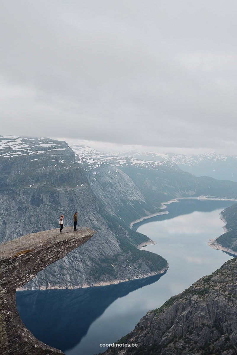 The two of us standing on the Trolltunga cliff, rising above the Ringedalsvatnet in the distance surrounded by mountains