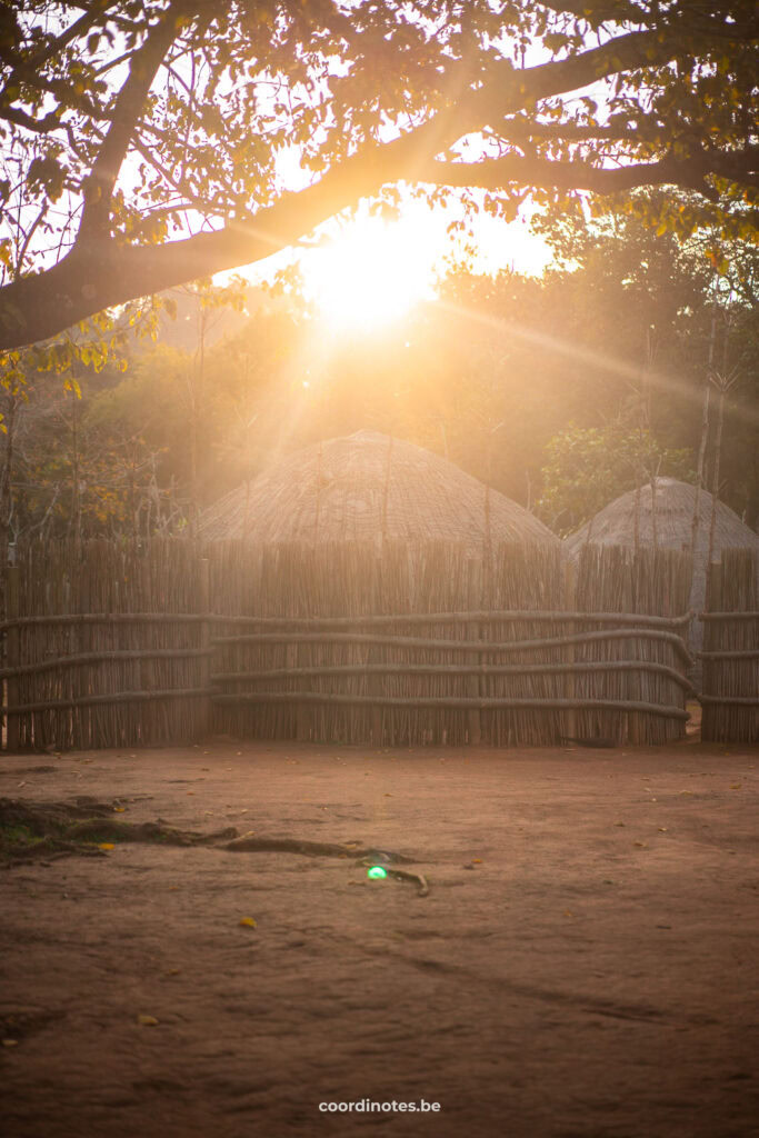 De zonsondergang boven de hutjes van het traditional dorp in Eswatini