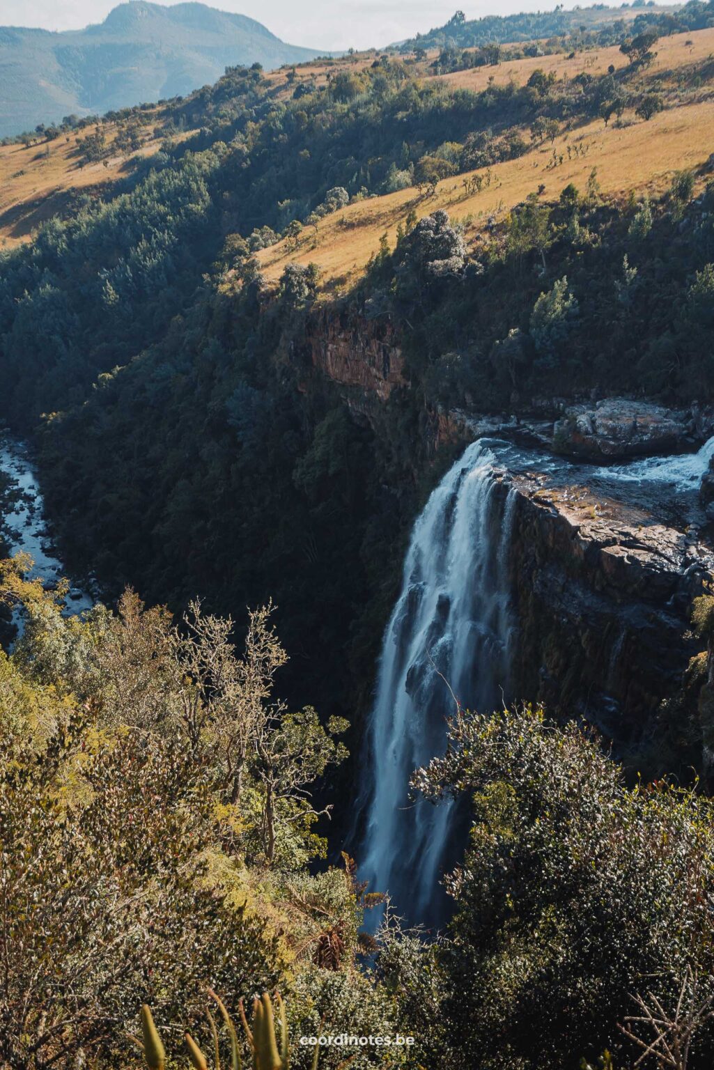 De Lisbon Falls waterval die van een klif naar beneden stort in een groen, glooiend landschap.