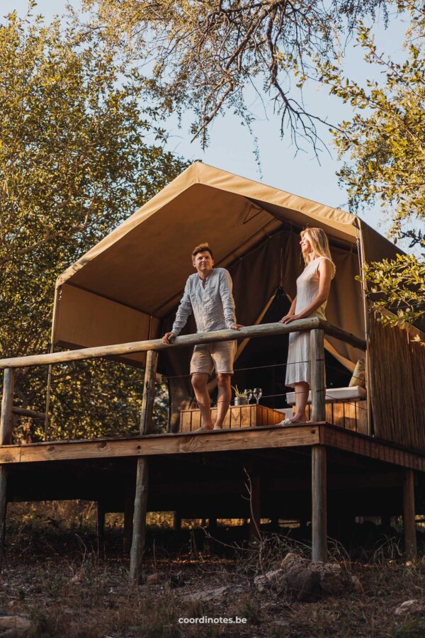 The two of us standing on a balcony in front of a glamping tent of Rukiya Safari Camp