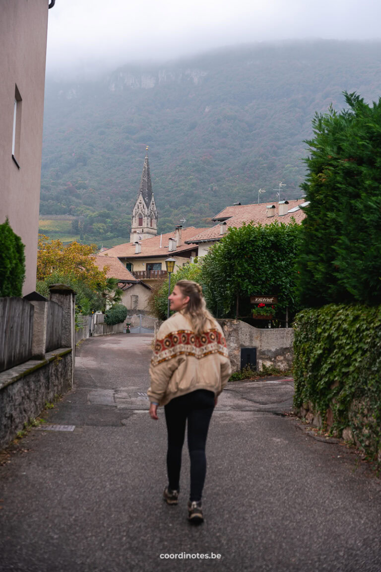 A woman walkking in a street with a church in the background