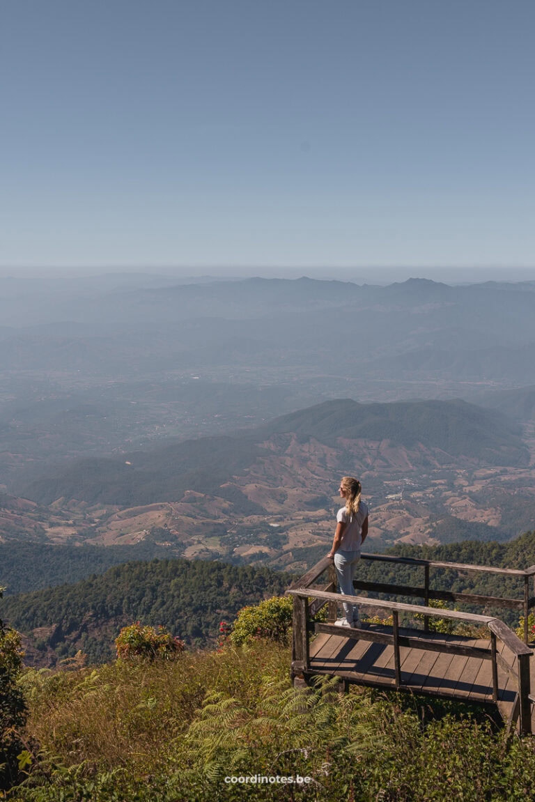 Sarah standing on a wooden platform watching over a mountainous landscape in the distance in Doi Inthanon National Park