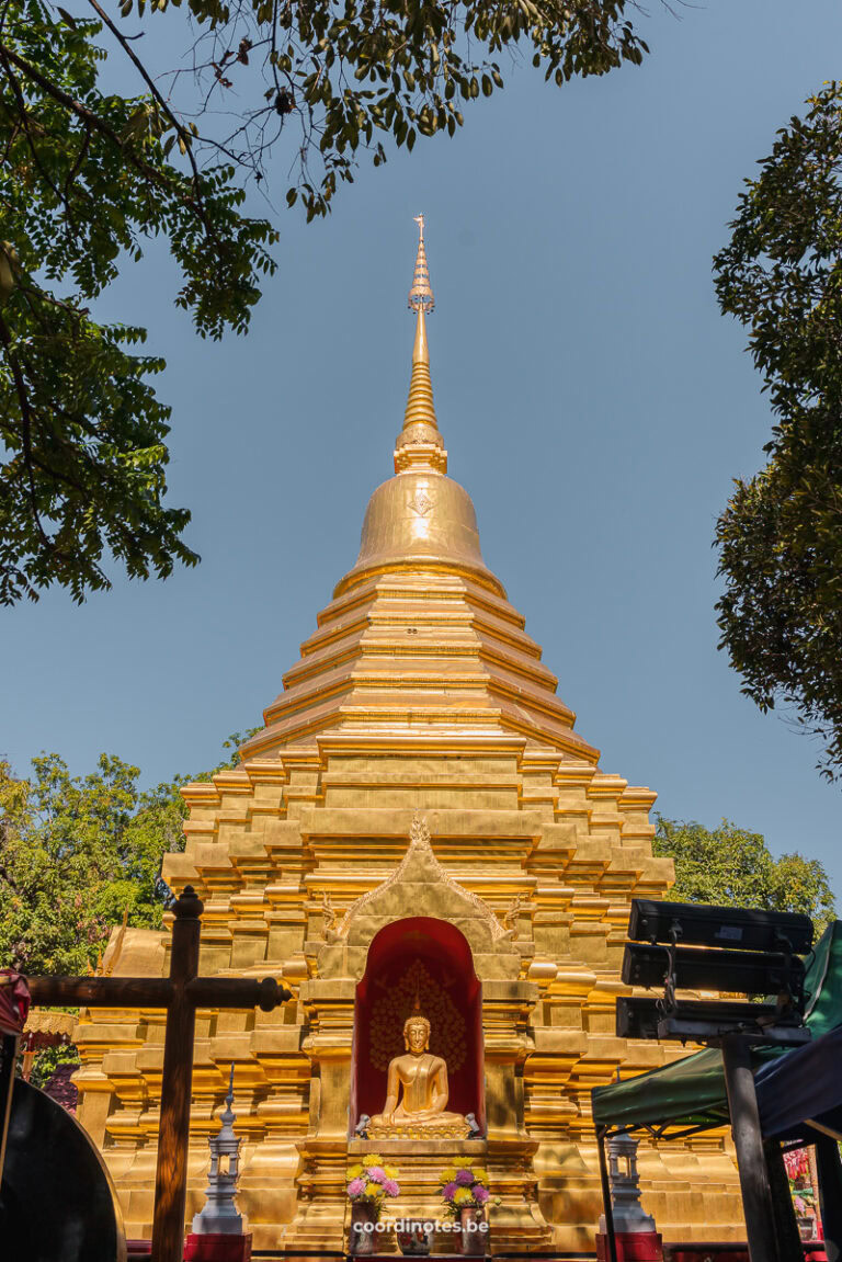 A huge golden stupa with a golden buddha inside.