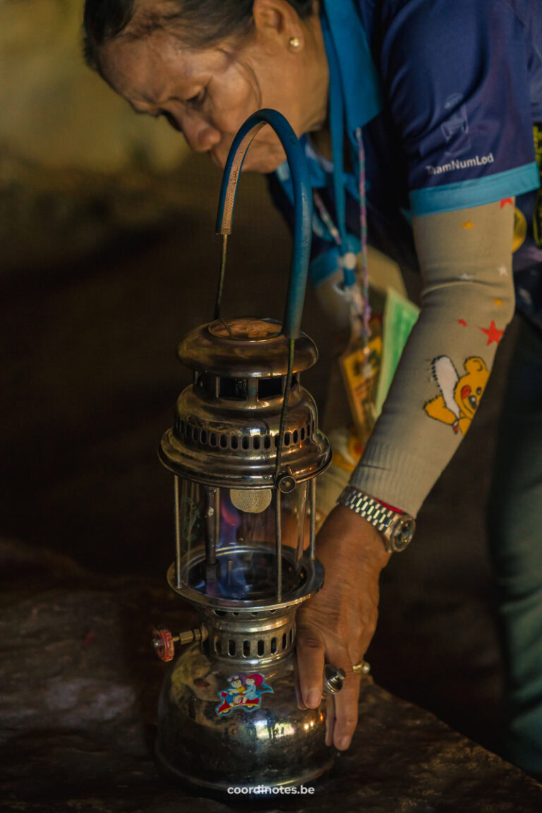 A Thai women lightning a traditional gas lamp in the Tham Lod Cave.