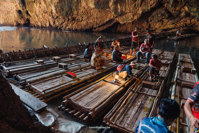 Thai guides sitting on bamboo rafts on the river inside the Tham Lod Cave.