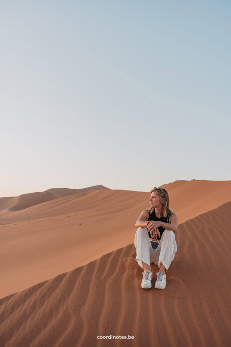 Sarah sitting on sand in Sossusvlei, Namibia